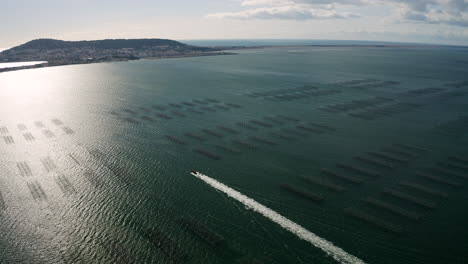 Wake-from-a-fast-small-fishermen-motorboat-in-the-Etang-de-Thau-with-Sète-aerial